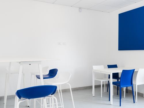 Sala mensa arredata con tavoli alti e bassi con sedute coordinate