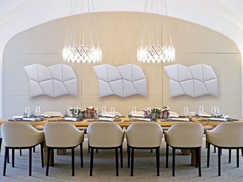 Scopri l'importanza della fonoassorbenza per garantire il comfort acustico! Vista di un tavolo diplomatico con alle spalle pannelli fonoassorbenti di design