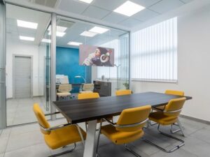 Ufficio diviso da pareti divisorie con scrivania in legno e sedie gialle