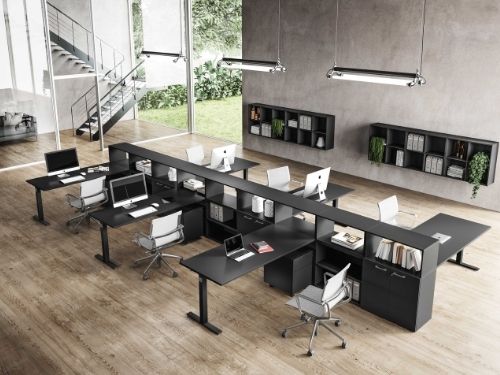Sala di lavoro open space con scrivanie di colore scuso perfettamente in armonia con l'ambiente circostante